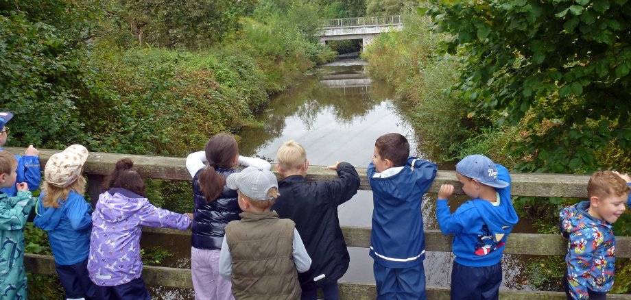 Kinder blicken auf den Moorbach